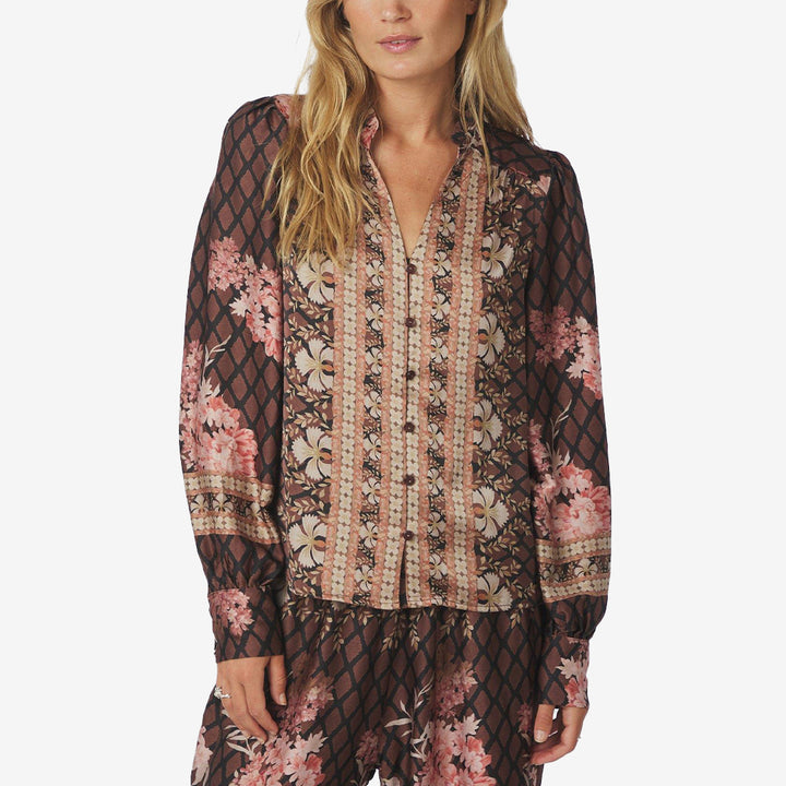Svart blus med blommigt grafiskt mönster, v-ringning och dekorativa knappar framtill