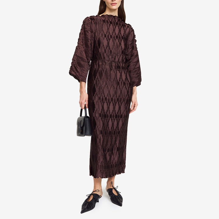 Klänning i färgen Coffee Brown i mjukt plissétyg med båtringning, vida ärmar och justerbart bälte.