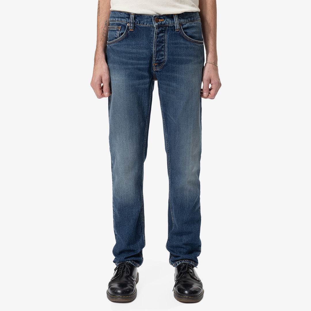 Nudie Jeans Solid Ollie Wild Blue slim fit-jeans för herr i Mid Blue Wash med smal benvidd och autentiska slitningar.