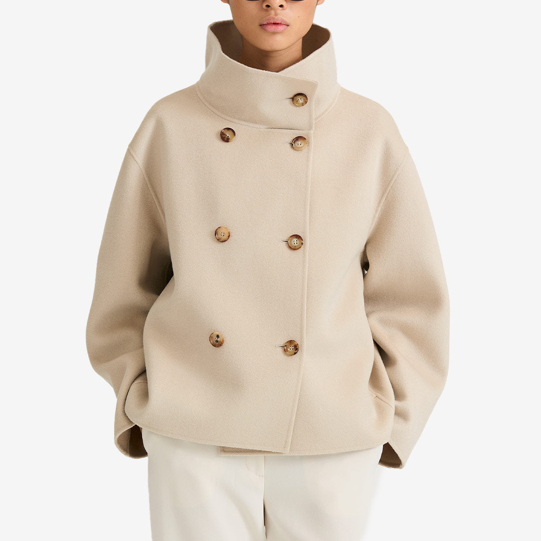 Stylein Tove Jacket – oysterfärgad kort ulljacka med funnel collar och asymmetrisk knäppning