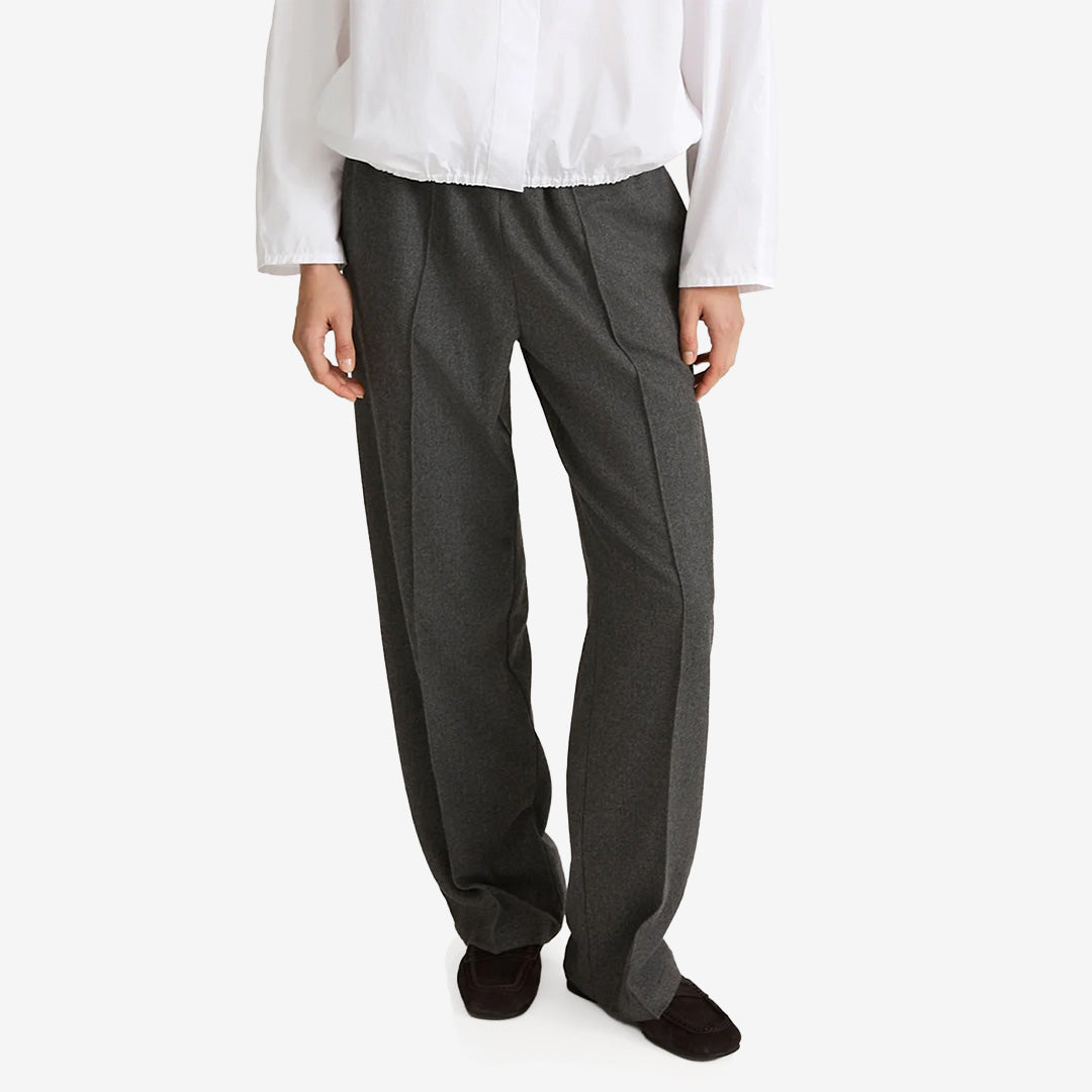 Stylein Belicia Trousers i Dark Grey, vida hellånga byxor i mjukt flanelltyg med resårmidja och snedställda sidfickor.