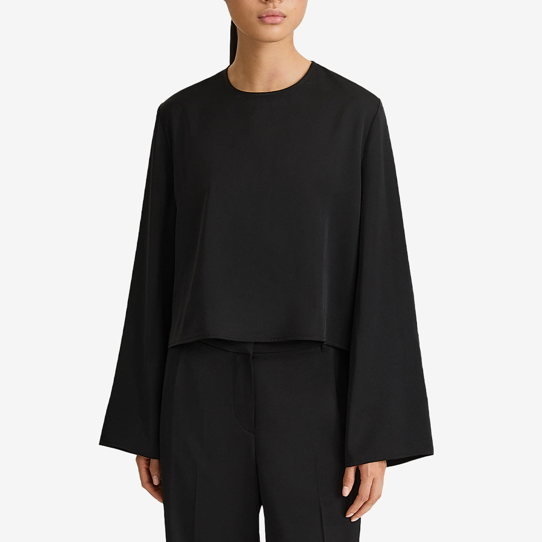 Stylein Mirai Blouse Black, svart kort topp i stretchig satin med rund halsringning och dramatiskt vida ärmar.
