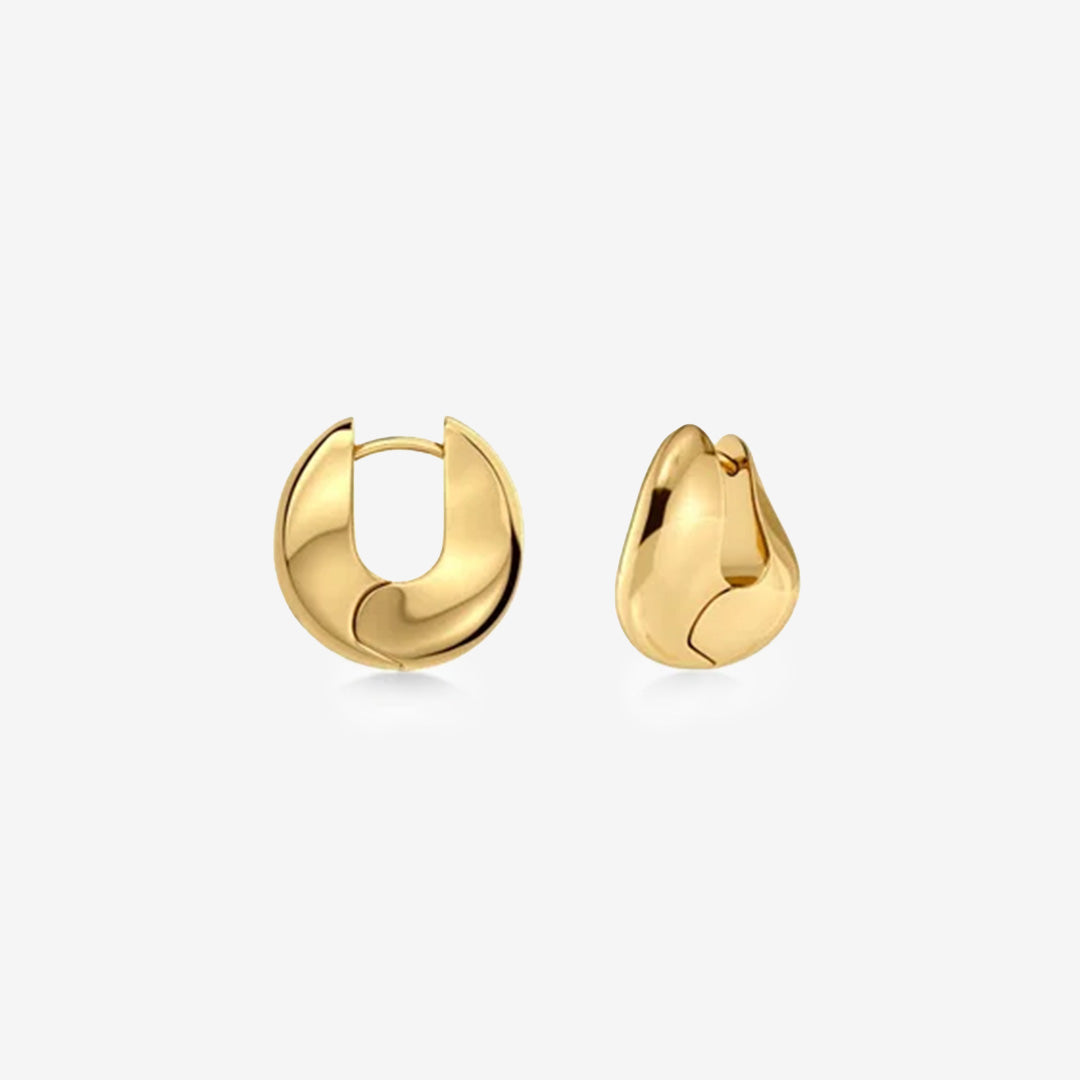 Små guldpläterade hoops med skulptural design som omsluter örsnibben