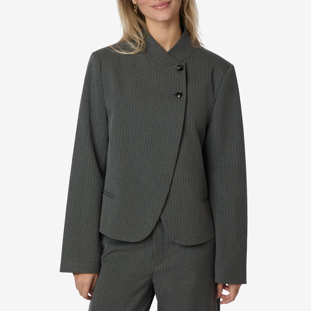 Neo Noir Tiria Slim Pinstripe Blazer i Grey, grå figurnära damkavaj med asymmetrisk knäppning och kritstrecksmönster.