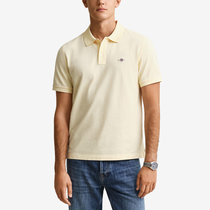 Kortärmad piqué polo från Gant i färgen vanilla yellow med regular fit, flatknitted krage och broderad sköld på bröstet