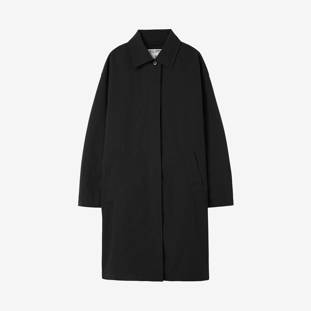 Cassie Car Coat i svart färg, ofodrad regnrock i återvunnen polyester med dold knappstängning och veckad ärm.