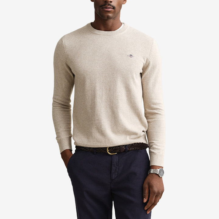 Rundhalsad tröja från Gant i 100 % bomull i färgen oat melange med ribbade detaljer och broderad sköld på bröstet