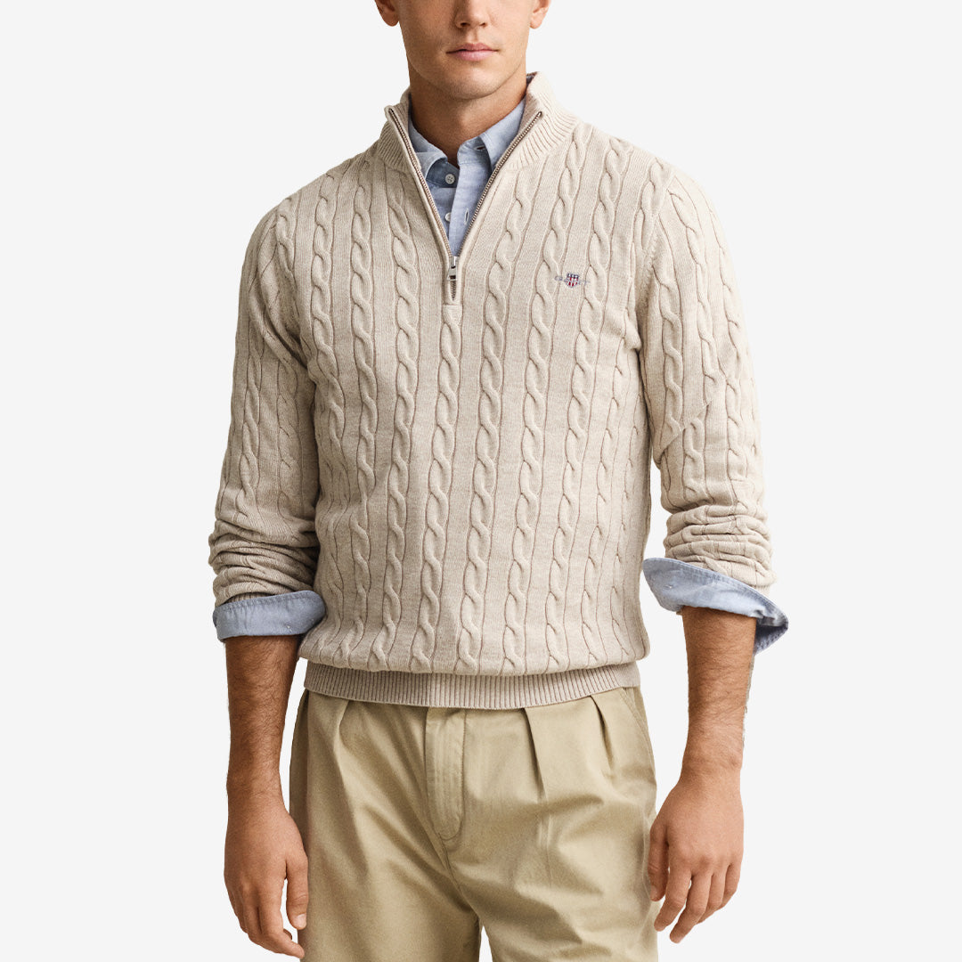 Kabelstickad tröja från Gant i 100 % bomull i färgen oat melange med halvdragkedjekrage och broderad sköld på bröstet