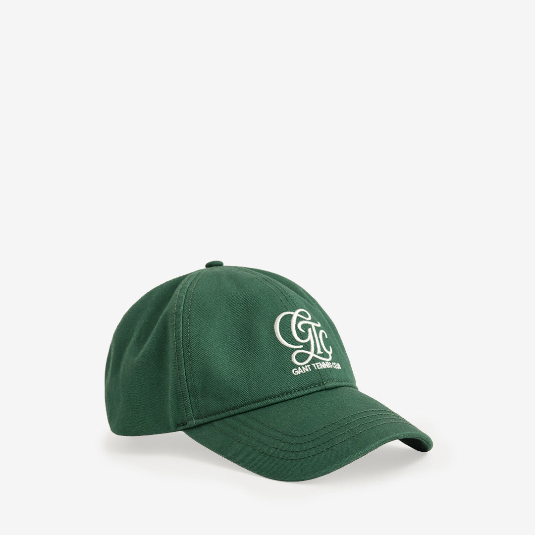 Gant Båstad Tennis Cap i bottle green med klassisk design och bekväm passform i 100% bomull.