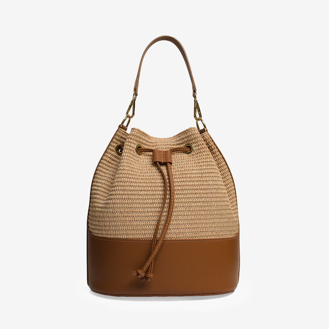 Bucket bag i strå och läder i färgen camel med axelrem och handtag