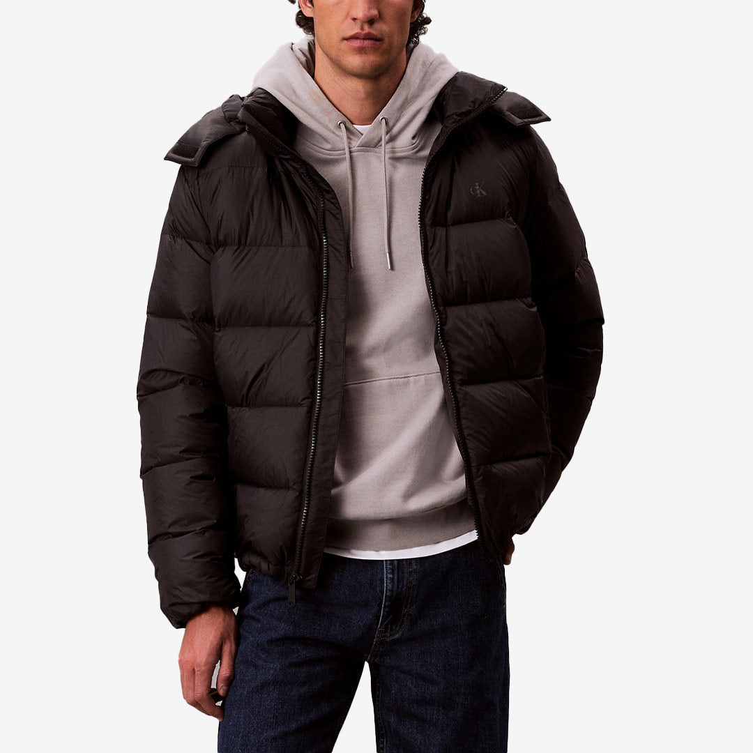 Svart vadderad dunjacka från Calvin Klein med avtagbar huva, ståkrage och tvåvägsdragkedja framtill.