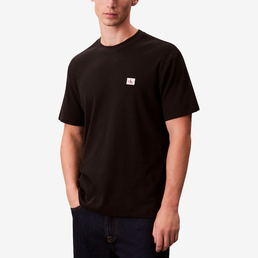 Svart waffle t-shirt SS Waffle Badge Crew i 60% bomull och 40% polyester med badge-detalj