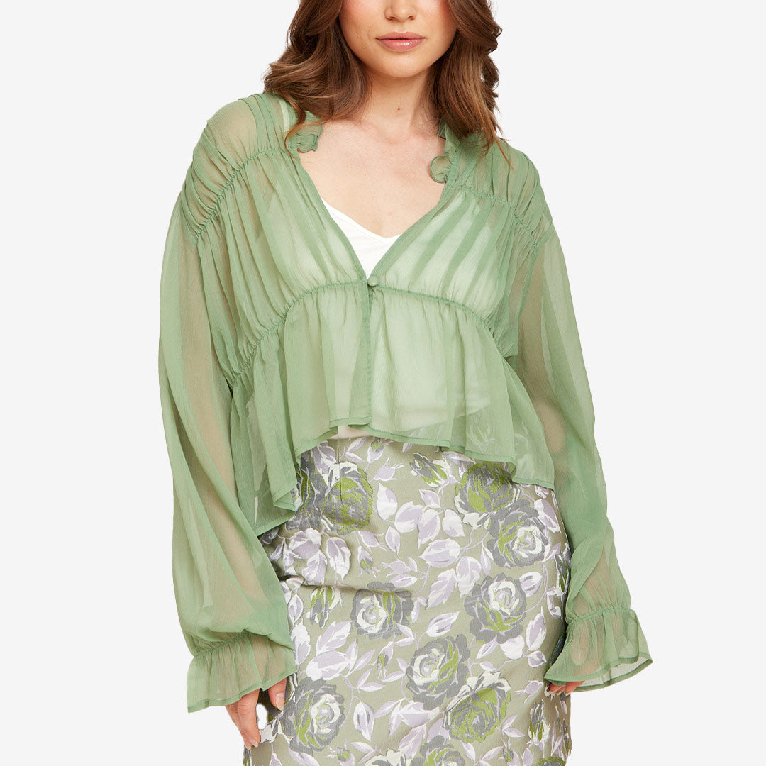 Grön blus från Rut & Circle för dam med transparent tyg, volymärmar och feminin design.