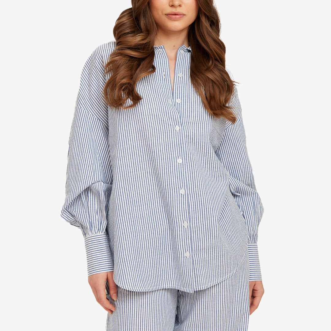 Blårandig skjorta från Rut & Circle för dam med lös passform, breda manschetter och rundad nederkant.
