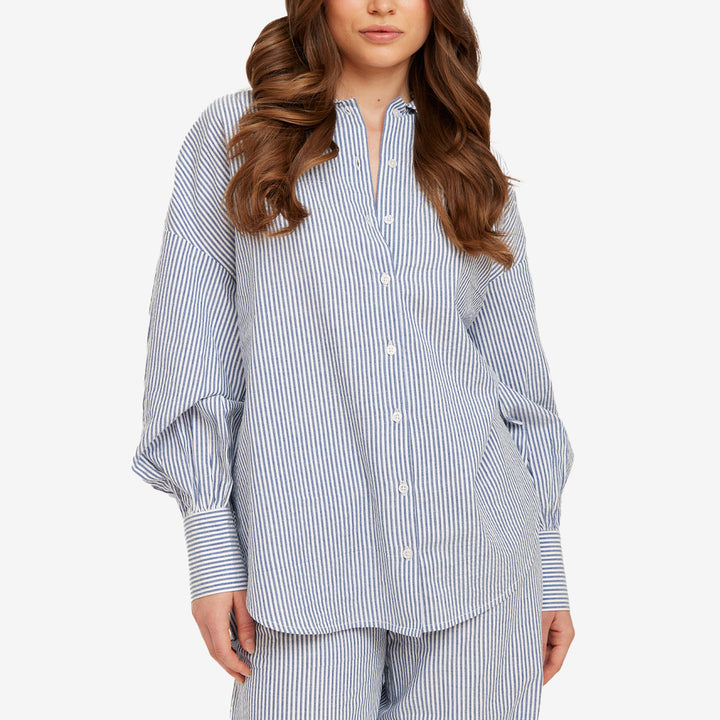 Blårandig skjorta från Rut & Circle för dam med lös passform, breda manschetter och rundad nederkant.