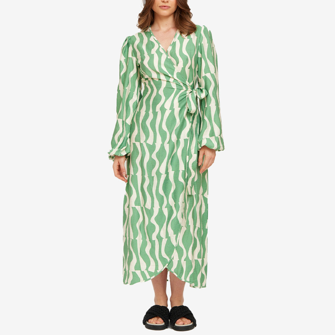 Grön omlottklänning från Rut & Circle för dam med mönster, knyt i midjan och lång silhuett.