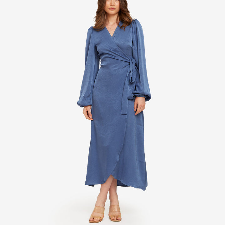 Blå omlottklänning från Rut & Circle för dam med knyt i midjan och lång, elegant design.